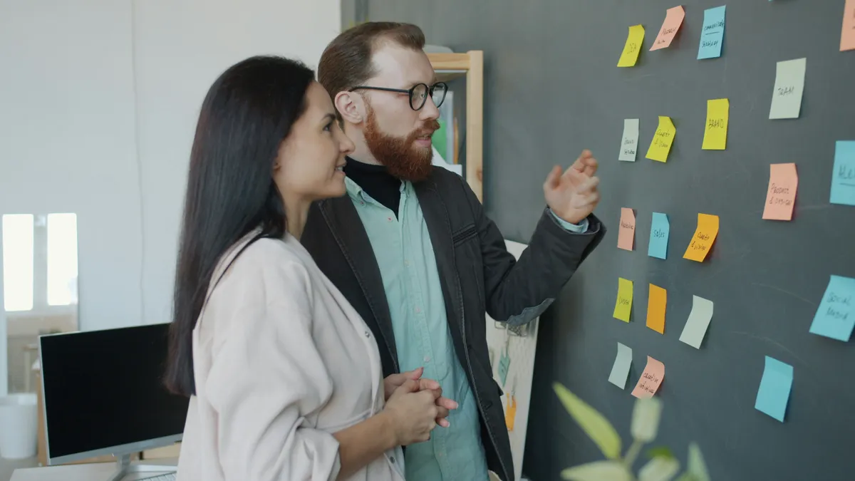 Business professionals reviewing plans and using software